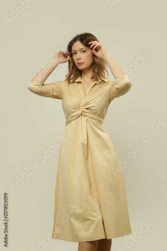 Woman Wearing an Elegant Beige Midi Dress with V Neck and Front Knot — Part of a Fashion Collection
