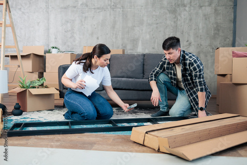 Cuadro en lienzo Young couple assembling furniture in new home living room