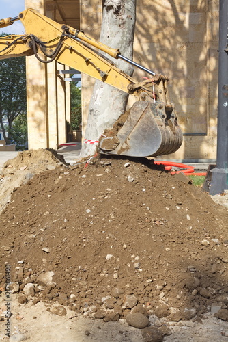 Konstfotografi Excavator bucket digging soil and gravel at an urban road reconstruction site