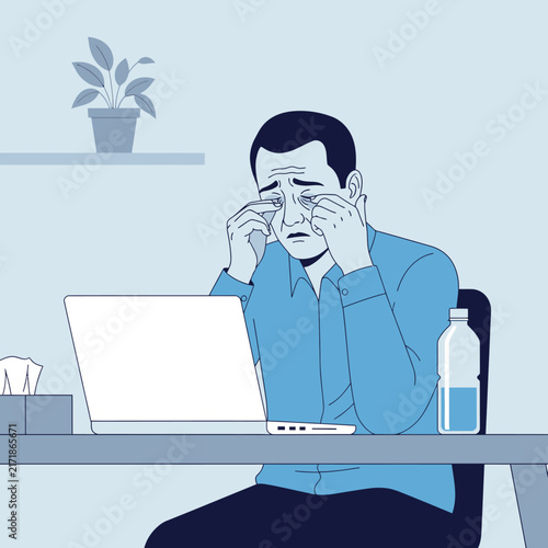 Stressed Businessman Rubbing Eyes While Working Late On Laptop