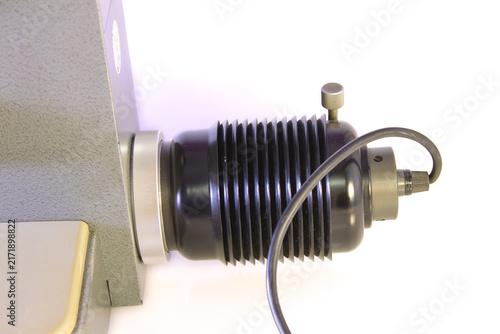 Fotografie Close-up of a vintage microscope illumination unit with a ribbed metal housing, adjustment knob, cable and optical components, isolated on a white background