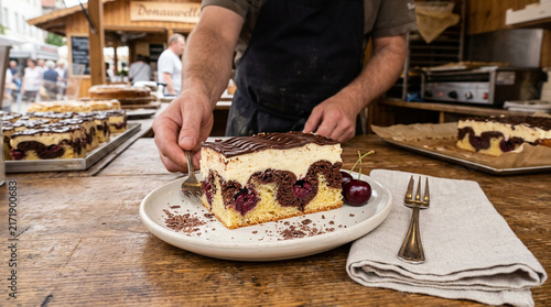 Artisan Baker Serving a Slice of Freshly Baked Cherry Cream Marble Cake at an Outdoor Market Stall