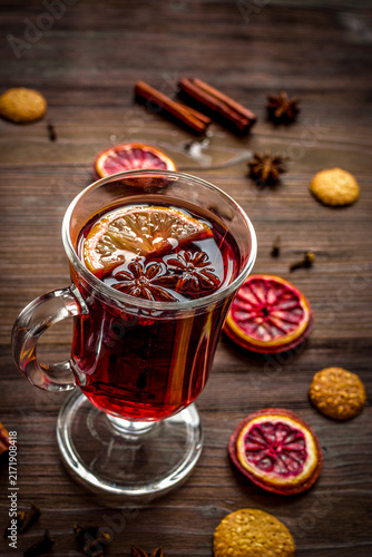 Fotografía mulled wine with spices in cup on wooden background