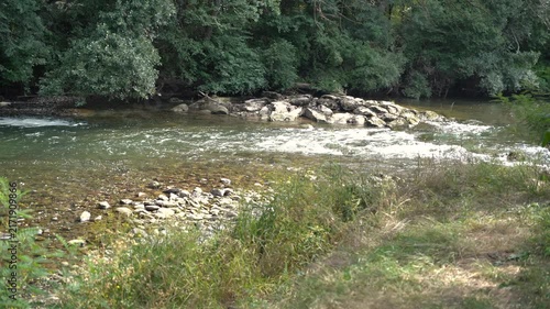 River rapidly flowing over the stone cascade in the forest