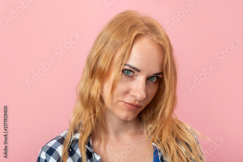 Obraz na płótnie Young woman with captivating green eyes and long blonde hair looking directly at