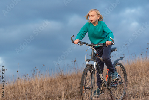 фотографія Young boy demonstrating focus and determination while riding his mountain bike a