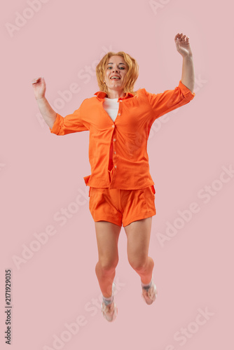 фотографія Happy woman smiling and jumping reaching for the sky, expressing joy, freedom, a