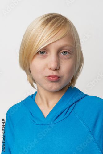 Konstfotografi Blonde haired child posing in a blue hooded sweatshirt, making a silly expressio