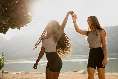фотографія Happy female friends holding their hands together in a playful celebratory gestu