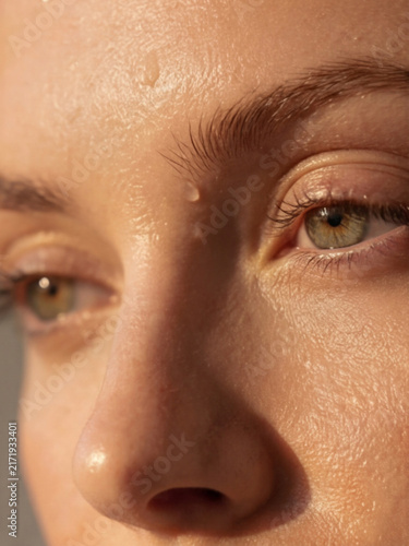 Extreme close up macro shot of young woman glowing skin texture and eyes