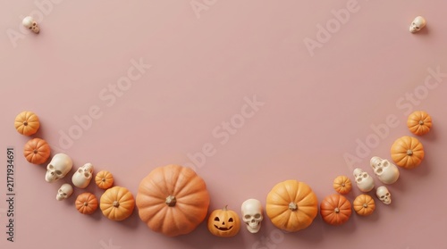 Halloween arrangement with pumpkins skulls and jackolantern on a pastel pink background