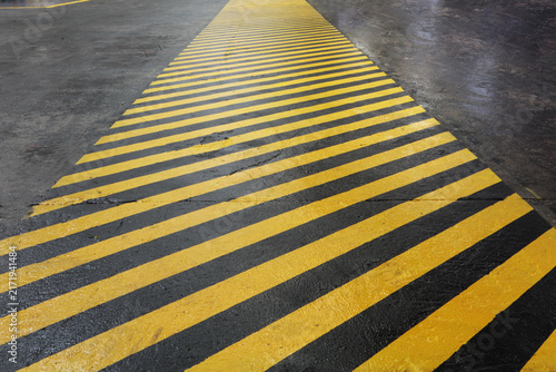 Canvastavla Yellow and black warning stripes on asphalt create impression of safety corridor stretching into distance