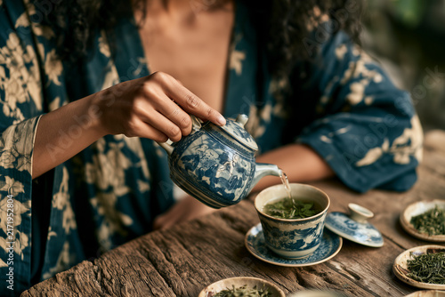Woman Preparing Tea In Teal Robe
