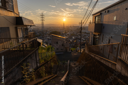 東京都日野市の郊外に広がる住宅街と送電鉄塔の夕景
