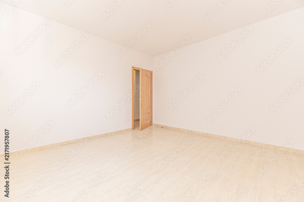 Fototapeta premium Empty room with beige tiled floor and open wooden door leading to adjacent space