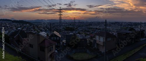 東京都日野市の郊外に広がる住宅街と送電鉄塔の夕景
