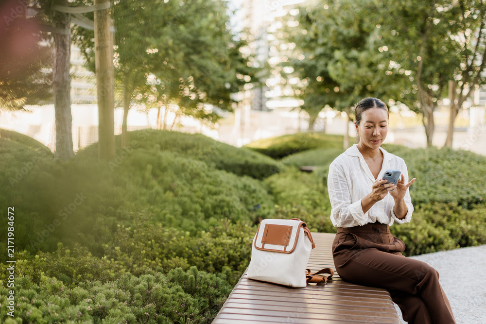 Fototapeta premium Korean woman enjoying a peaceful moment in a lush urban park setting