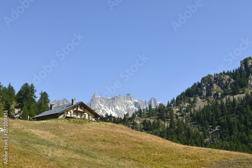 Traditional alpine hut with Dent du Geant peak in Mont Blanc massif background, Plan Checrouit, Courmayeur, Aosta Valley, Italy