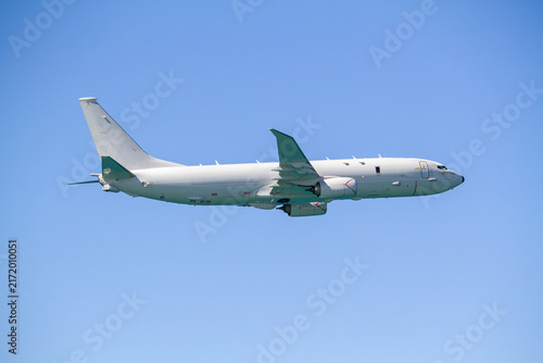 Obraz na plátně P-8 Poseidon maritime patrol aircraft flying in side profile against a clear blue sky, showing its swept wings, twin jet engines, fuselage and distinctive aircraft design