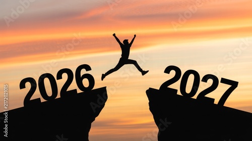 Person jumping between 2026 and 2027 year mountains at sunset