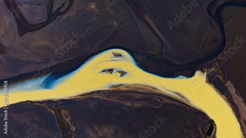 Aerial view of Tungnaa river with its distinctive yellow glacial sediment winding through the dark volcanic landscape of the highlands, Skaftarhreppur, Iceland.