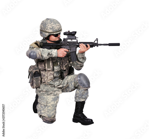 Soldier in camouflage uniform kneeling with rifle.