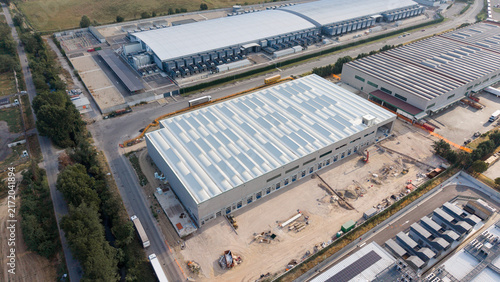 Aerial view of newly built data centers alongside construction of a logistics center in an industrial area, showing expanding digital and commercial infrastructure in Siziano, Lombardy, Italy.