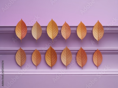 Twelve orange metallic dry leaves arranged in two horizontal rows on purple architectural molding ledges. Minimalist composition featuring symmetrical autumn foliage on a lavender background.