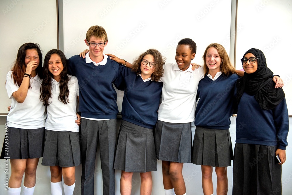 Fototapeta premium Group of diverse students in school uniforms smiling together.