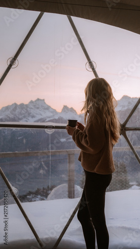 фотографія Person enjoying a warm drink while gazing at mountain views
