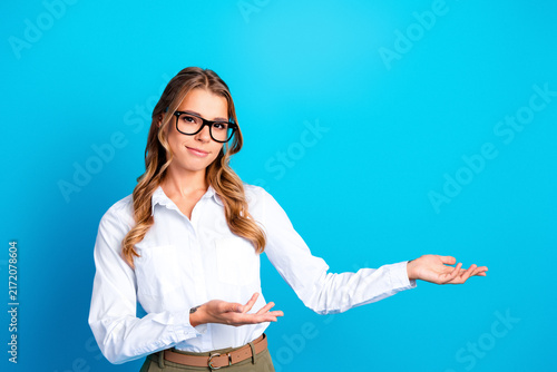 Canvas Print Professional woman presenting with open hands against a bright blue background,