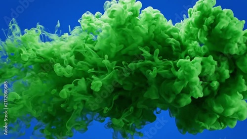 Green Ink Dispersing in Blue Water Creating Abstract Cloud Motion.