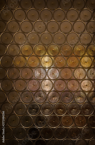 Dark glass with a pattern of circles in close-up. Abstract background patterned glass