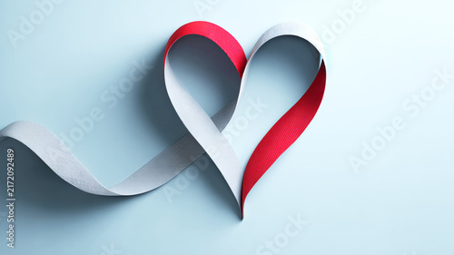 Red and white ribbon in shape of heart on light background symbolizes healthcare, support, and medicine. for Doctor’s Day, medical ads, charity campaigns, posters, blogs, web, awareness projects