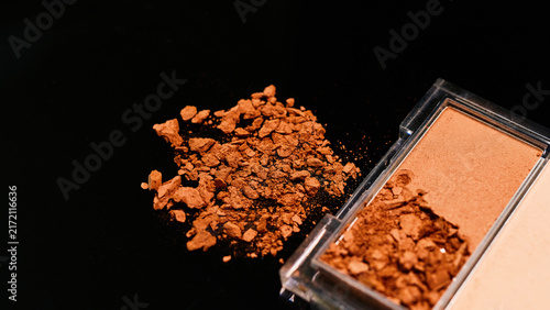 Canvastavla Close up of makeup powder spilled next to its compact on black surface