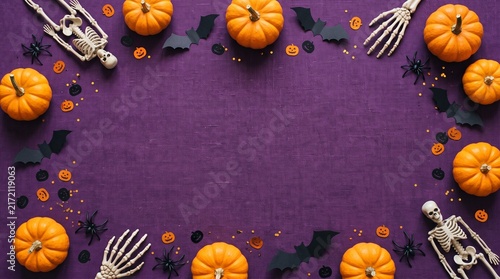 Halloween decorations on violet background. Flat lay pumpkins, bats, spiders, skeletons and confetti. Top view with copy space. Halloween concept.