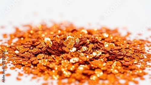 Abstract pile of shiny orange glitter particles on white background