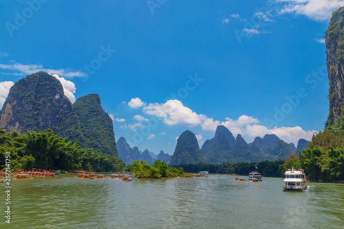 Canvas Print Guilin, China, a passenger boat cruises the emerald Li River beneath dramatic ka