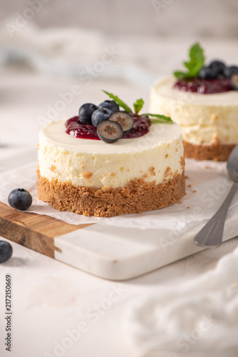 Mini cheesecakes with blueberry topping on a wooden board