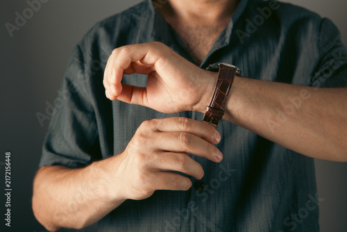 фотографія Man checking time on his wristwatch