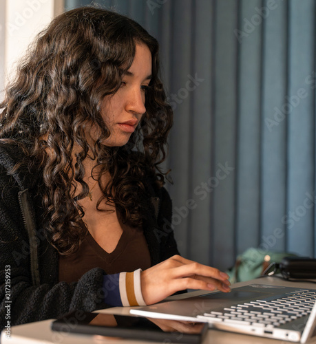 фотографія Young woman concentrating on laptop for work or study