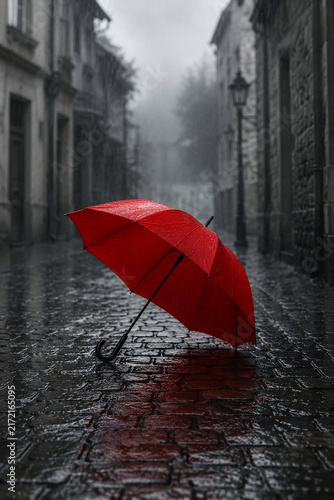 Red Umbrella on Wet Cobblestone Street in Rain with Selective Color Effect