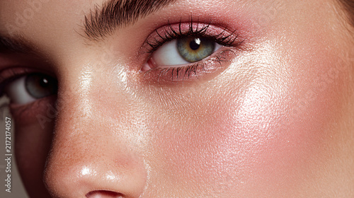 Close-up of a young woman's face emphasizing eye, skin, and makeup details