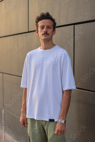 Blank white oversized t-shirt mockup on a young male model, urban street style apparel template