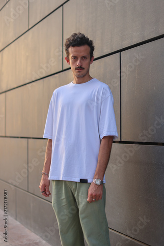 Blank white oversized t-shirt mockup on a young male model, urban street style apparel template