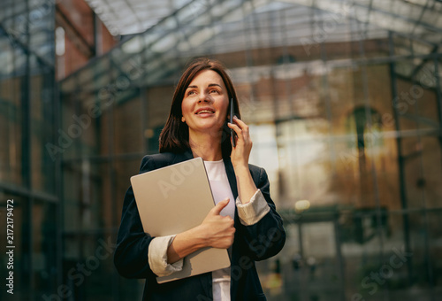 Businesswoman talking on a smartphone outside the office