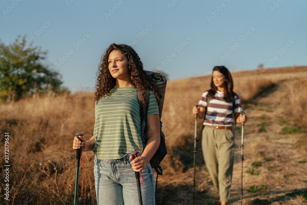Naklejka premium Two women hiking outdoors on a rural path