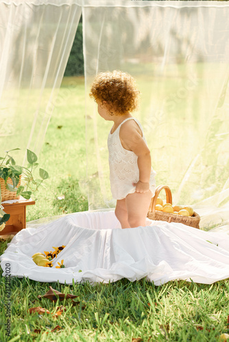 Curly-Haired Little Girl Enjoying a Peaceful Outdoor Bath in the Garden
