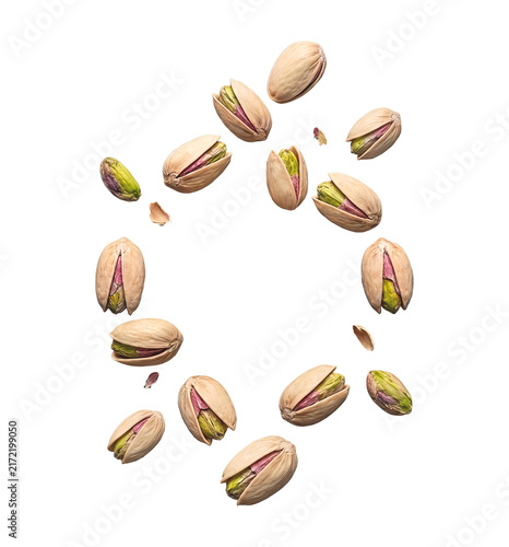 Beautiful swirl of flying pistachio nuts forming a floating circular frame