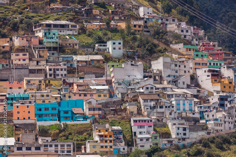 Fototapeta premium Colorful colorful houses and dense residential buildings built on the hillside slopes in Quito, Ecuador, against Andean mountain background.
